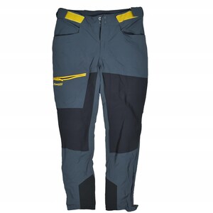 May include: Dark gray outdoor pants with black panels on the knees and lower legs. The pants have yellow accents on the pockets and waistband. The Bergans logo is visible on the left pocket. These pants are designed for outdoor activities.