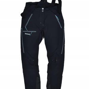 May include: Black outdoor pants with suspenders. The pants have multiple pockets with teal zippers and the brand name "Simond" is visible on the front. The pants have a button and zipper closure and are designed for outdoor activities.