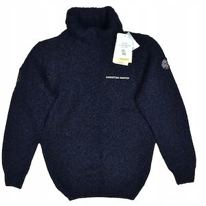 Puede incluir: Un jersey de cuello alto azul marino con el texto "CHRISTIAN RADICH" en el pecho. El jersey tiene una etiqueta adjunta y un pequeño parche en la manga izquierda. El jersey está hecho de un tejido de punto grueso y texturizado.