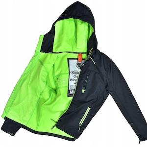 May include: Black hooded windbreaker jacket with a bright neon green interior. The jacket has a zipper closure, two front pockets, and a small tag with text. The jacket is designed for outdoor activities.