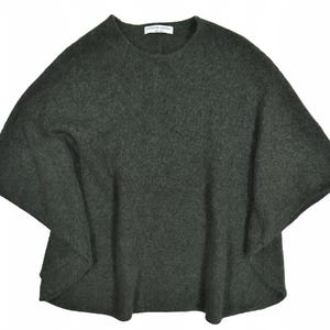 May include: A dark gray poncho-style sweater with a round neckline and wide sleeves. The sweater is made of a soft, textured material. The label "Catherine Malandrino" is visible at the neckline.