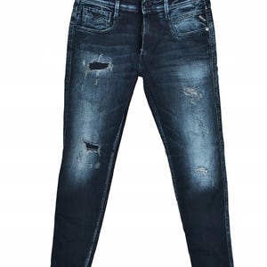 Peut inclure: Jean en denim délavé foncé avec des détails déchirés. Le jean présente plusieurs déchirures et décolorations, avec une coupe classique à cinq poches. Le nom de la marque "REPLAY" est visible. Un style moderne et décontracté.