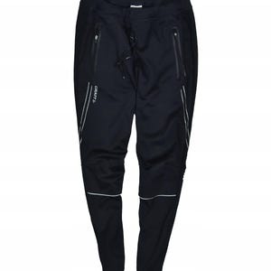 May include: Black athletic pants with white reflective stripes and zippers. The pants have a drawstring waist and the brand name "CRAFT" is visible on the left leg. These pants are designed for running or other outdoor activities.
