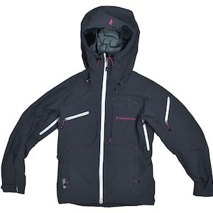 May include: A dark gray hooded jacket with a white zipper and accents. The jacket has multiple pockets with white zippers and pink accents. The hood has a pink logo. The jacket is designed for outdoor activities.