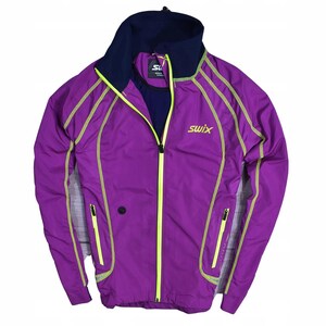 Puede incluir: Chaqueta Swix morada con cuello azul marino y costuras amarillo neón. La chaqueta tiene cremallera completa, dos bolsillos laterales y el logotipo de Swix en el pecho. Diseñada para actividades al aire libre.