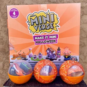 May include: MGA's Miniverse Make It Mini Halloween craft kit box featuring orange sunburst graphics and text. Three spherical orange containers with Halloween-themed patterns sit in front, each holding miniature craft supplies and accessories.