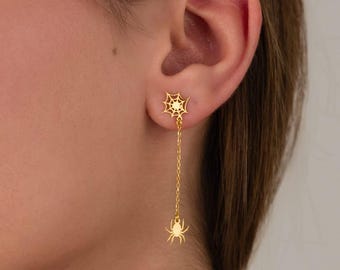May include: Gold spider web and spider dangle earrings. The earrings feature a delicate spider web design with a dangling spider charm.