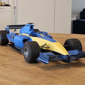 May include: A blue and yellow toy racing car with black wheels. The car has a spoiler and a detailed design.