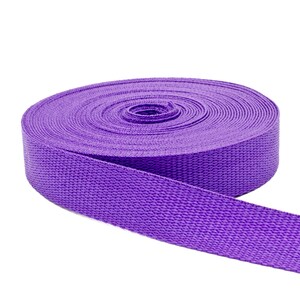 May include: A roll of purple webbing, a type of strong, woven fabric often used for straps and belts.