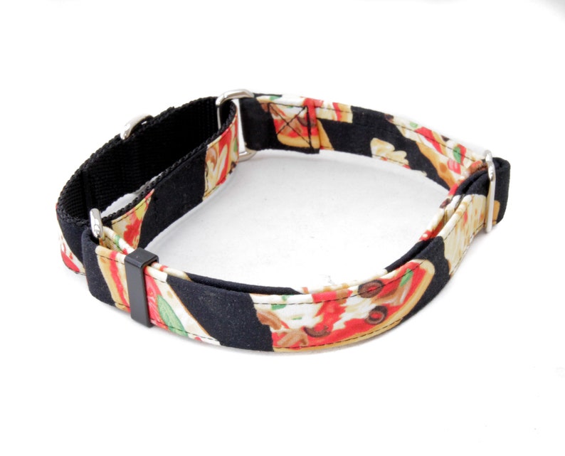 May include: A black and white dog collar with a pizza print. The collar is made of fabric and has a metal buckle.