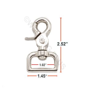 Puede incluir: Mosquetón giratorio de metal plateado con una longitud de 6,4 cm, una anchura de 3,7 cm y una abertura de 2,6 cm.