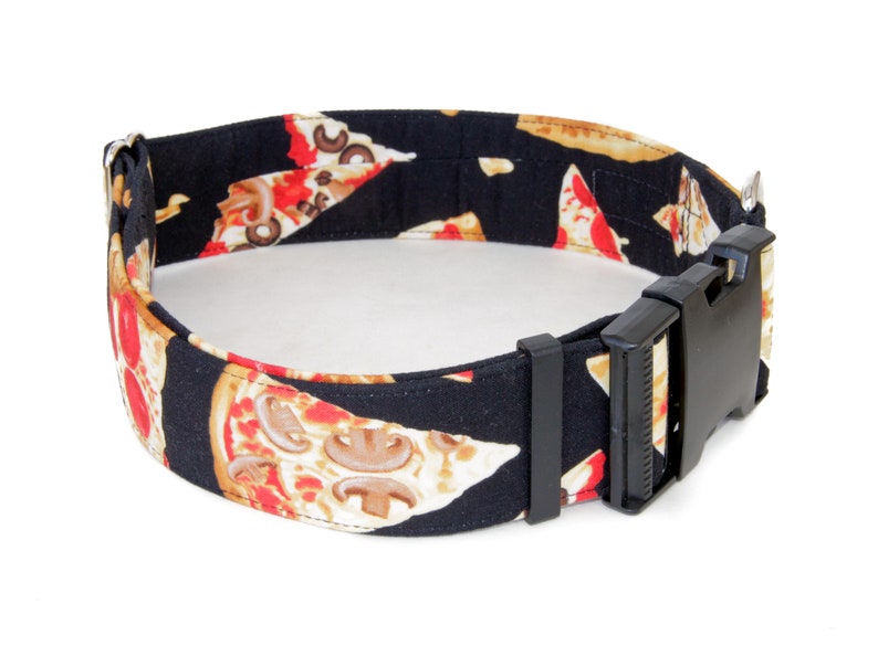May include: A black dog collar with a pizza print. The collar has a black plastic buckle.