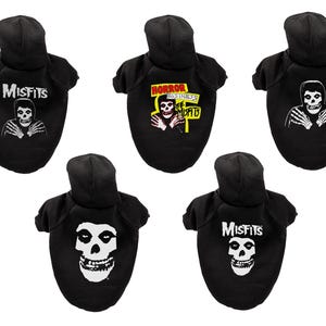 Könnte beinhalten: Schwarze Hunde-Hoodies mit weißen Grafiken des Misfits-Schädellogos und verwandten Designs. Die Hoodies haben eine Kapuze und sind für Hunde konzipiert. Der Text "Misfits" ist auf einigen Hoodies aufgedruckt.