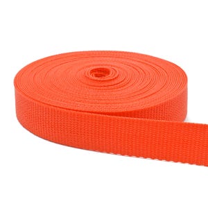 May include: A roll of bright orange webbing, a type of heavy-duty fabric used for straps, belts, and other applications.