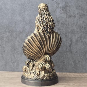 K&ouml;nnte beinhalten: Eine bronzefarbene Skulptur, die eine Figur mit langem, lockigem Haar zeigt, die in einer gro&szlig;en, gerippten Muschel sitzt. Der Sockel der Skulptur weist stilisierte, wirbelnde Wellenmuster auf, alles in einer metallischen, verwitterten Bronzeoptik.