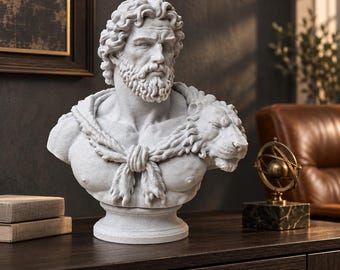 May include: A light gray stone-textured bust of a bearded man with curly hair, wearing a lion skin draped over the shoulders and tied at the chest. The sculpture features detailed facial expressions, including a furrowed brow and a thick beard.