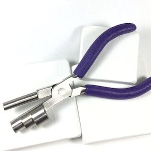 May include: Purple handled pliers with a silver metal loop and a series of metal rings on the end of the pliers.
