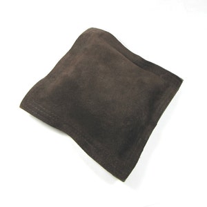 May include: A brown suede pouch with a stitched seam around the edges.