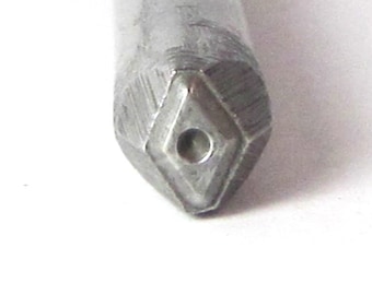 May include: Close-up of a silver metal punch tool with a diamond-shaped tip and a small hole in the center.