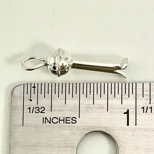 May include: Silver-toned metal clasp with a round ball on one end and a hook on the other. The clasp is about 1 inch long.