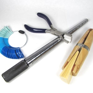 May include: A set of jewellery making tools including a ring mandrel, ring sizer, and a pair of pliers with blue handles.