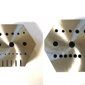 May include: Two hexagonal metal plates with a variety of different sized holes drilled into them. The plates are silver in color and have a brushed finish.