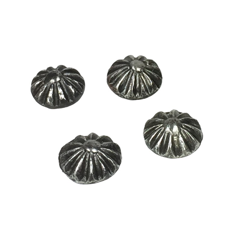 May include: Four silver-toned metal decorative nail heads with a raised, starburst design.
