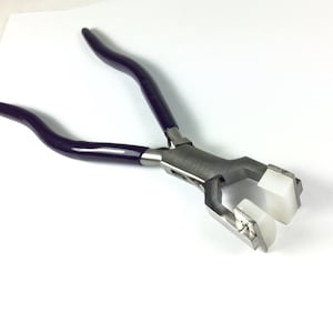 May include: Purple handled pliers with white plastic jaws for crimping jewelry findings.