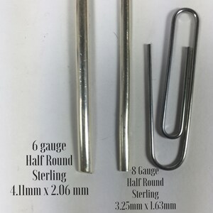 Może przedstawiać: Dwa kawałki srebrnego drutu p&oacute;łokrągłego, jeden o grubości 6, a drugi o grubości 8. Drut o grubości 6 ma wymiary 4,11 mm x 2,06 mm, a drut o grubości 8 ma wymiary 3,25 mm x 1,63 mm.