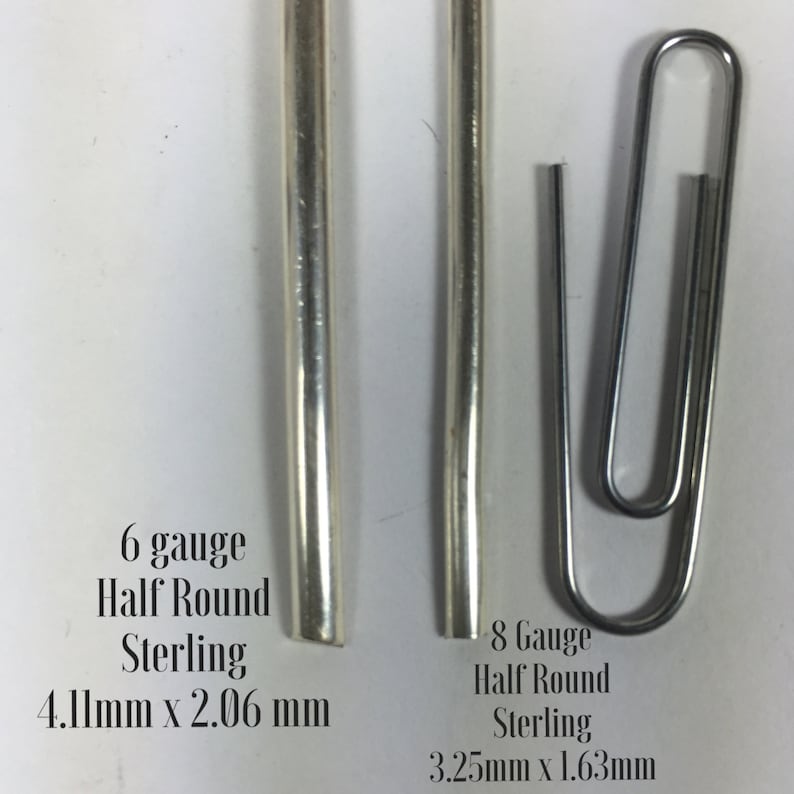Może przedstawiać: Dwa kawałki srebrnego drutu p&oacute;łokrągłego, jeden o grubości 6, a drugi o grubości 8. Drut o grubości 6 ma wymiary 4,11 mm x 2,06 mm, a drut o grubości 8 ma wymiary 3,25 mm x 1,63 mm.
