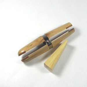 May include: A wooden ring mandrel with a metal clamp and a wooden wedge. The mandrel is used to size rings.