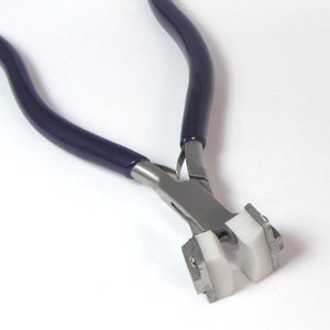 May include: A pair of silver-toned pliers with blue rubber handles and white plastic jaws. The pliers are designed for crimping jewelry.