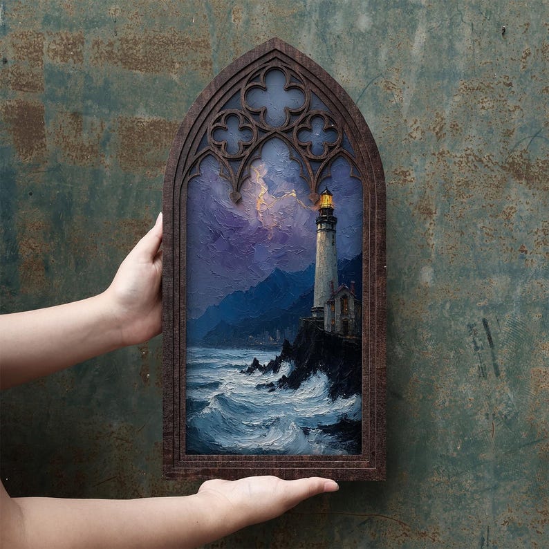 May include: A rectangular wall art piece featuring a painting of a lighthouse on a rocky cliff overlooking a turbulent ocean at night, framed in dark wood with a gothic-style arched top containing decorative quatrefoil cutouts.