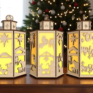 Op de afbeelding: Drie houten lantaarns met uitgesneden kerststalscènes en sterontwerpen. Elke lantaarn heeft een warme gele gloed van binnenuit, wat een feestelijke sfeer creëert. De lantaarns staan op een houten oppervlak, met een kerstboom op de achtergrond.
