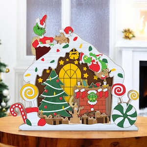Letrero navideño de dulces, divertido ladrón de dibujos animados escabulléndose por la chimenea, decoración navideña de varias capas de pan de jengibre, adorable decoración invernal.
