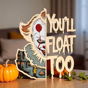 May include: Wooden Halloween decoration featuring a clown face with a red balloon and the text "You'll Float Too." The design includes a haunted house and a small pumpkin. The color palette includes orange, red, white, and blue.