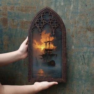 May include: A dark brown wooden frame with a pointed gothic arch top containing a printed image of a tall ship sailing on water during a sunset. The sky is filled with orange and yellow clouds, and the ship is silhouetted against the light.
