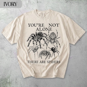 T-shirt with spiders and text "YOU'RE NOT ALONE THERE ARE SPIDERS".