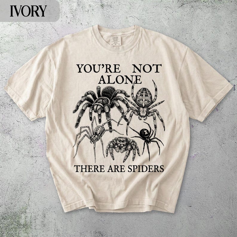 T-shirt with spiders and text "YOU'RE NOT ALONE THERE ARE SPIDERS".