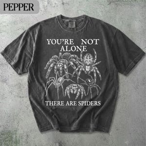 Comfort Colors t-shirt with spiders and "YOU'RE NOT ALONE THERE ARE SPIDERS" text.