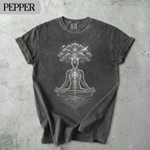 May include: Dark grey t-shirt featuring a meditating figure with a tree-like head and chakra symbols. The word "PEPPER" is printed at the top left. The shirt has a vintage, washed appearance.