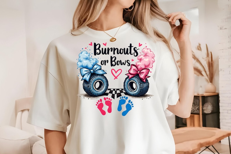 K&ouml;nnte beinhalten: Wei&szlig;es T-Shirt mit einem Aufdruck von zwei Baby-Fu&szlig;abdr&uuml;cken, einem rosa und einem blauen. Der Aufdruck enth&auml;lt auch zwei Reifen mit Schleifen, einen blauen und einen rosa, sowie den Text "Burnouts or Bows".