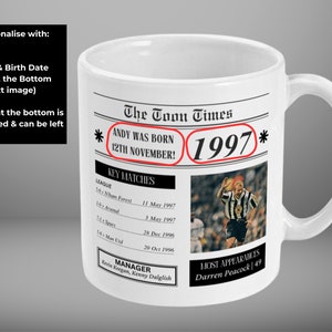 May include: White ceramic mug with a newspaper design featuring the text "The Toon Times" and "ANDY WAS BORN 12TH NOVEMBER!" with the year 1997. The mug has a black handle.