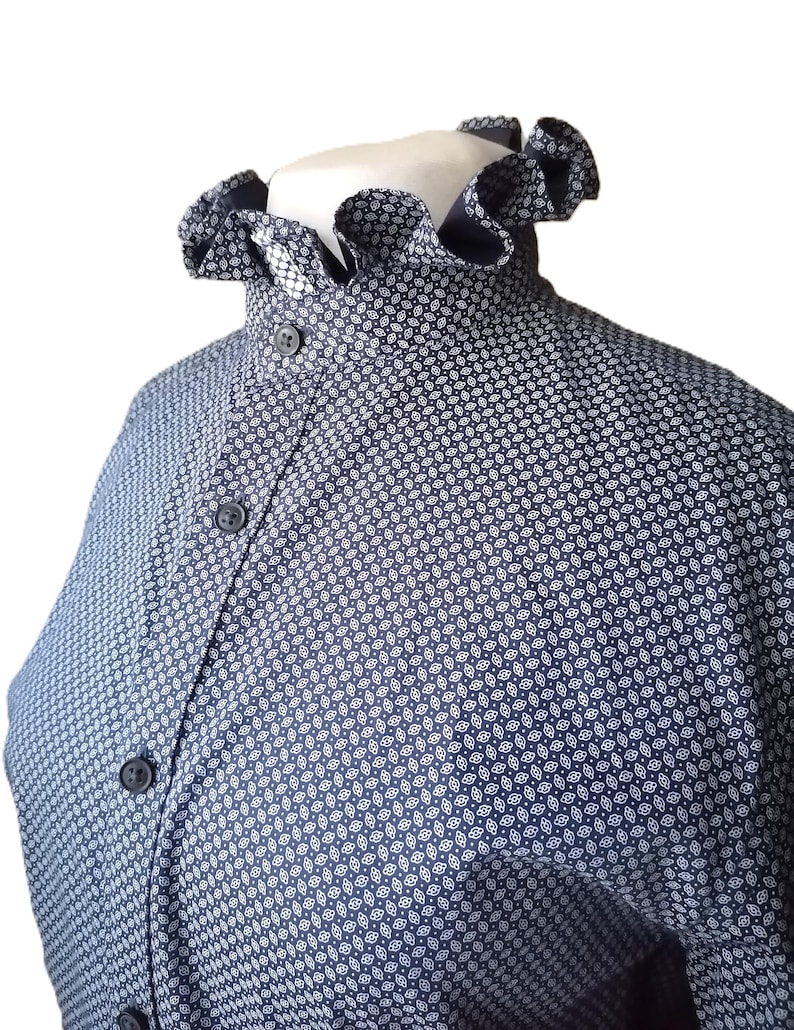 May include: A navy blue shirt with a white patterned design and a ruffled collar.