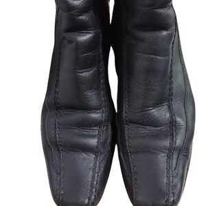 May include: A pair of black leather ankle boots with a pointed toe and decorative stitching.