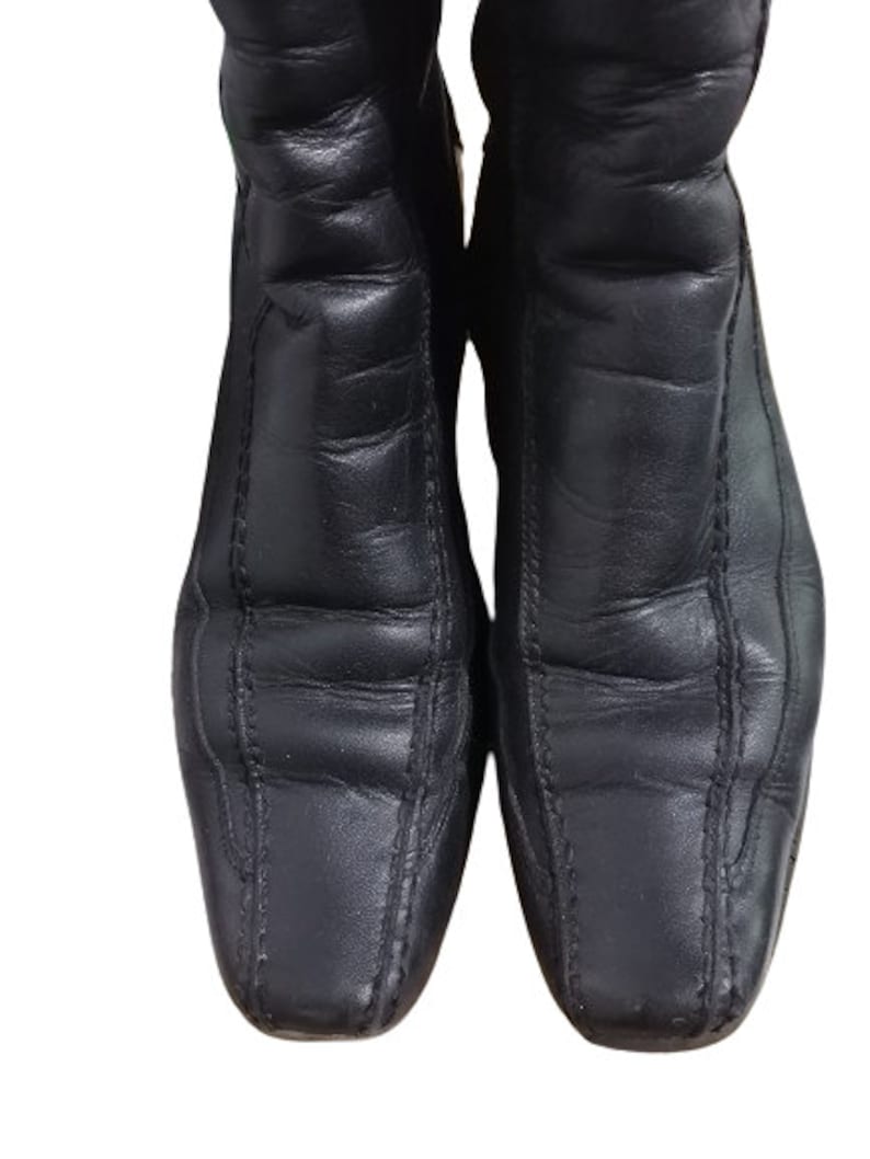 May include: A pair of black leather ankle boots with a pointed toe and decorative stitching.