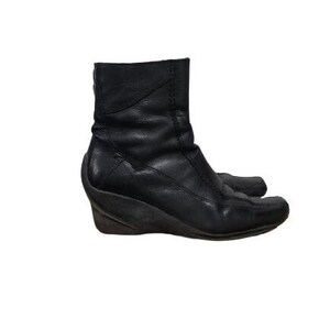 May include: Black leather ankle boots with a wedge heel. The boots have a pointed toe and a zip on the inside of the ankle.