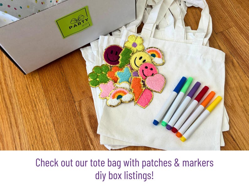 May include: White tote bags with colorful patches and markers. Patches include smiley faces, hearts, and rainbows. Markers are blue, green, purple, red, orange, and yellow. The text says, "Check out our tote bag with patches & markers diy box listings!"