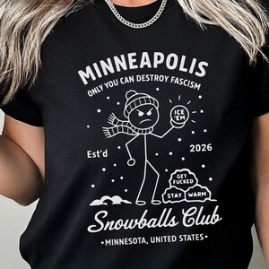May include: Black t-shirt with a white graphic that reads "MINNEAPOLIS ONLY YOU CAN DESTROY FASCISM" and "Snowballs Club". The graphic includes a stick figure with a hat and scarf, and the text "ICE 'EM".