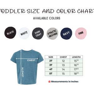 May include: A toddler size and color chart displays available t-shirt colors: black, white, dark gray, athletic heather, navy, and pink. A blue t-shirt shows chest and length measurements in inches. The chart includes sizes 2T to 5T.